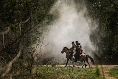 Panoramic view of people riding horse