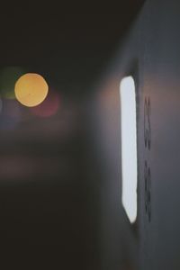 Close-up of illuminated lights against wall at night