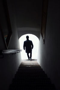Rear view of silhouette man walking in corridor