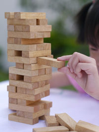 Cropped image of girl playing block removal game on table