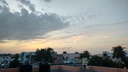 Houses in town against cloudy sky