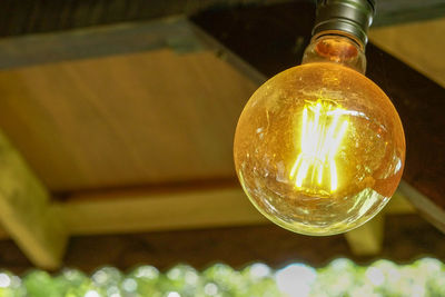 Low angle view of illuminated light bulb on table