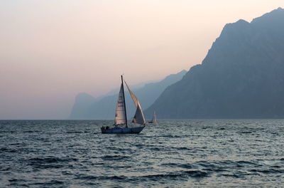 Boat sailing on sea against foggy sky