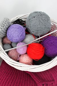 Direct above shoot of multi colored wool balls in basket on table at home