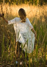 Rear view of woman standing on field