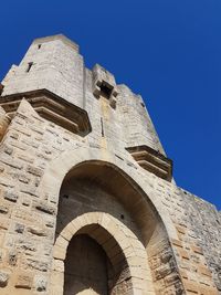 Low angle view of historical building against clear blue sky