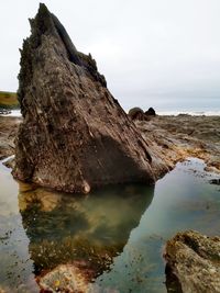 Rock formations by sea against sky