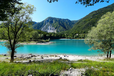 Scenic view of lake and mountains against clear blue sky