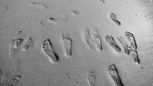 High angle view of footprints on sand at beach