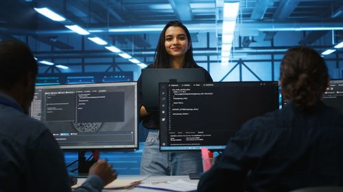 Portrait of young woman using laptop at office