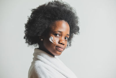 Portrait of young woman against white background