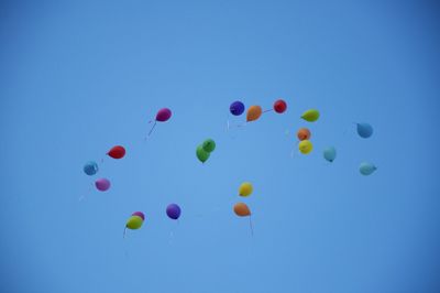 Low angle view of balloons against blue sky