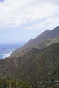 Scenic view of sea and mountains against sky