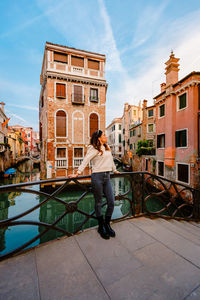 Woman on bridge with characteristic venetian building behind her