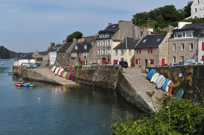 Houses by river against buildings in city