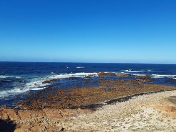 Scenic view of sea against clear blue sky