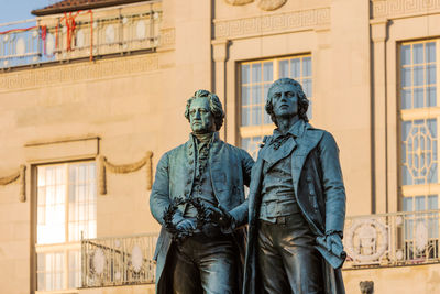 Low angle view of statue against building in city