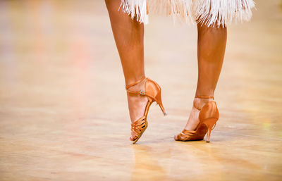 Low section of woman wearing high heels dancing on floor