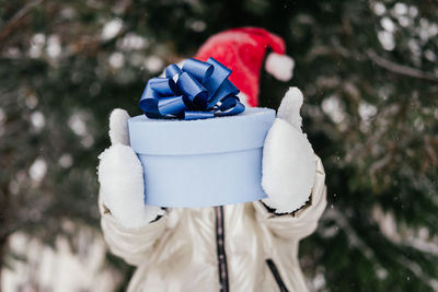 Girl holding gift box standing outdoors