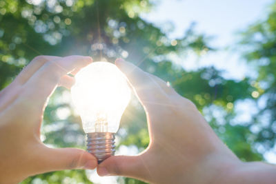 Midsection of person holding illuminated lighting equipment