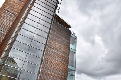 Low angle view of glass building against sky