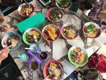 Cropped image of people having food at table in restaurant