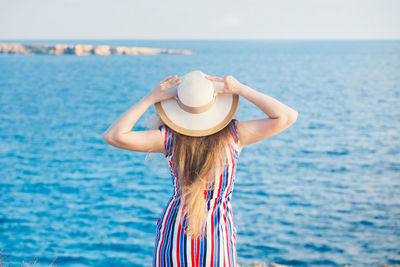 Midsection of woman in sea against sky