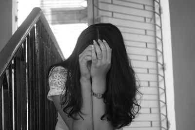 Close-up of woman standing against wall