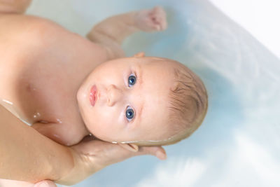 High angle view of baby boy lying on bed at home