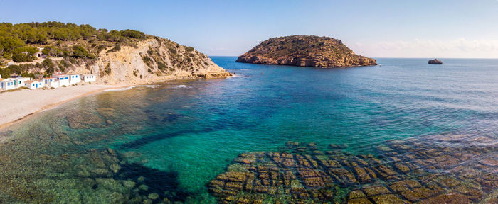 Panoramic view of rocks on sea shore against sky