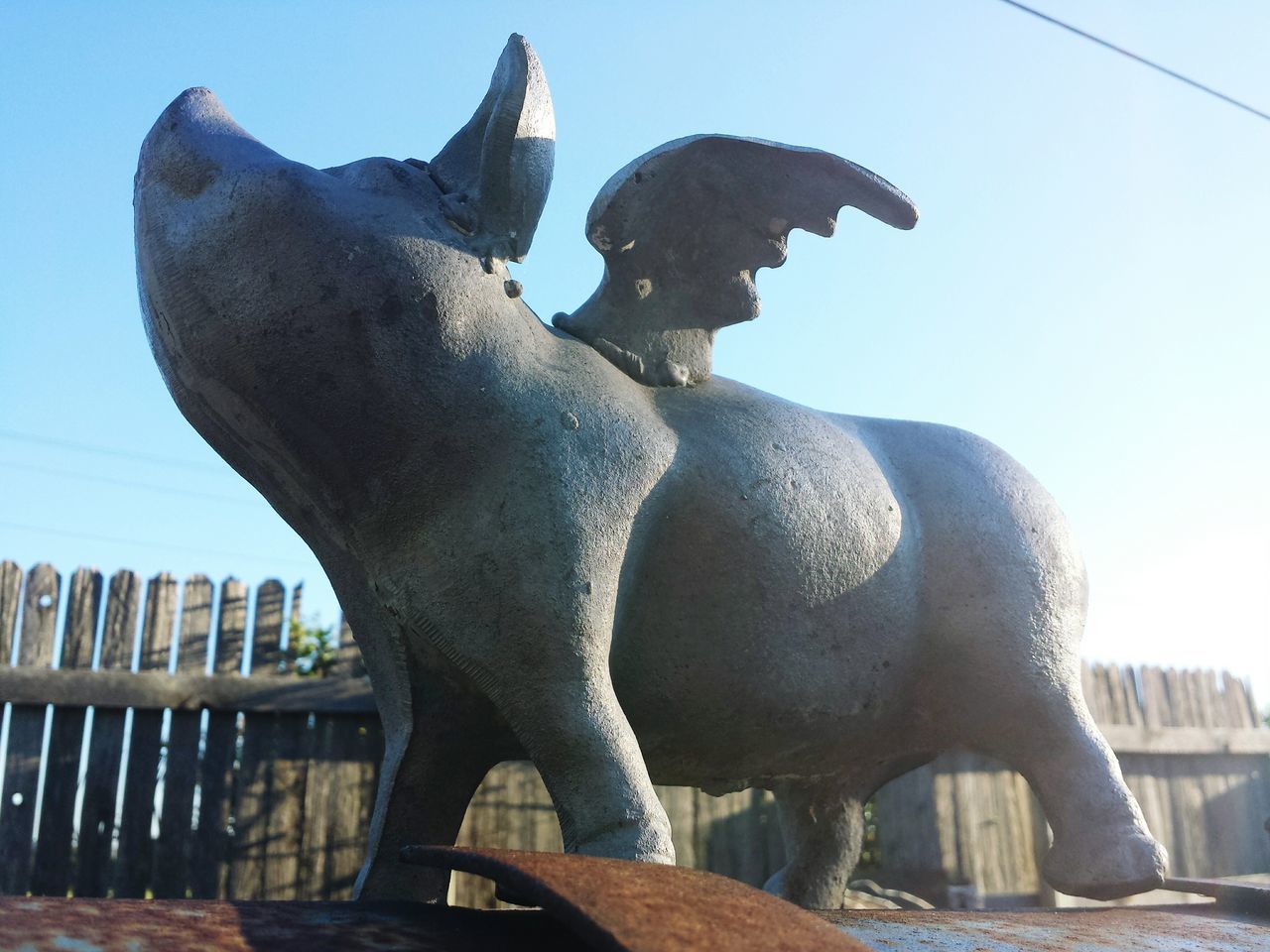 clear sky, sculpture, statue, sunlight, low angle view, art and craft, animal representation, built structure, art, day, close-up, architecture, sky, outdoors, no people, creativity, railing, shadow, focus on foreground, sunny