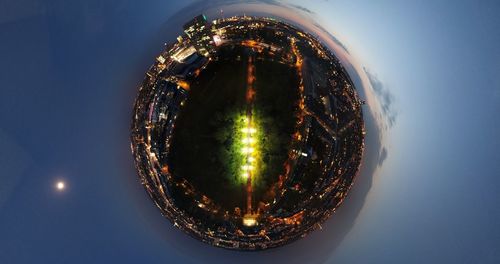 Directly below shot of illuminated cityscape against sky at night