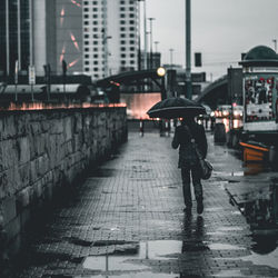 Man walking on wet road during rainy season