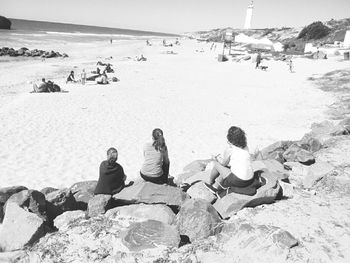 Rear view of people sitting on beach