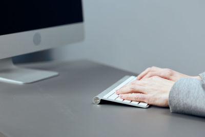 Cropped hand using laptop on table