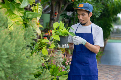 Young man standing by plants