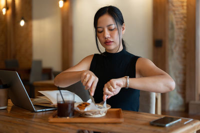 Portrait of young woman working at table