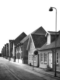 Houses by street against sky