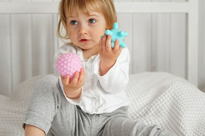 Baby girl playing tactile knobby balls. young child hand plays sensory massage ball