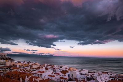 Scenic view of sea against dramatic sky during sunset