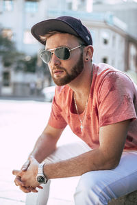 Young man wearing sunglasses sitting outdoors