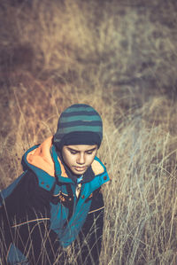 Cute boy sitting on grassy field