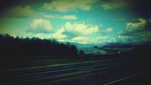 Railroad track against cloudy sky