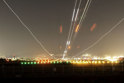 Low angle view of illuminated cityscape against sky at night