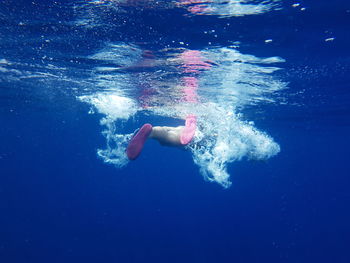 Low section of man swimming underwater