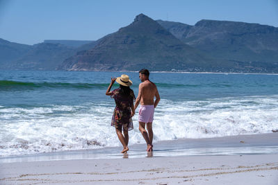 Rear view of woman standing at beach