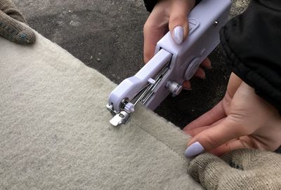 Cropped image of woman sewing carpet