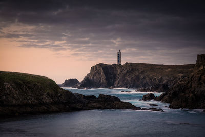 Meiras or punta frouxeira lighthouse over the cliffs at sunset