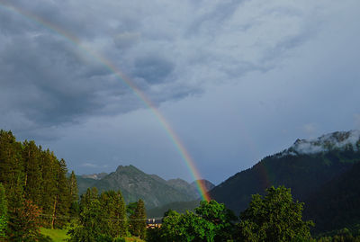 Scenic view of rainbow over mountains against sky