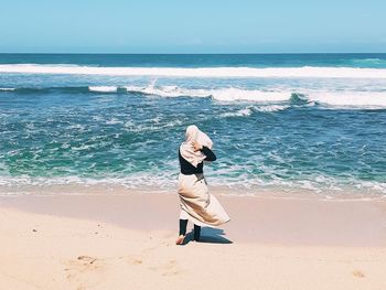 Woman on beach against sea